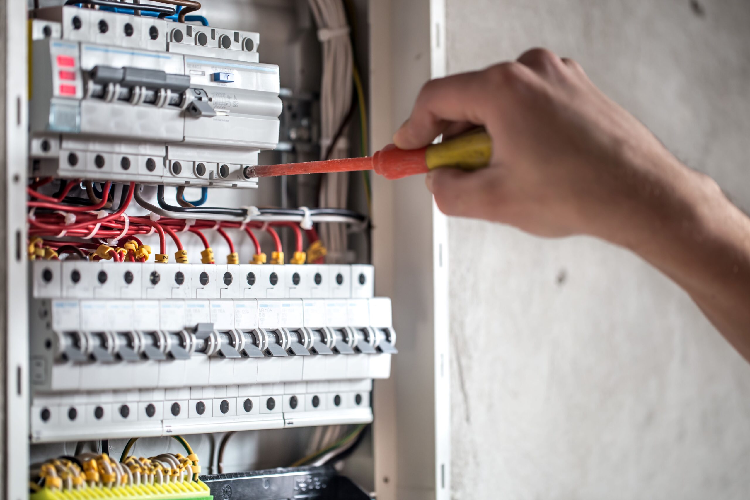 man-electrical-technician-working-switchboard-with-fuses-installation-connection-electrical-equipment-close-up-resize